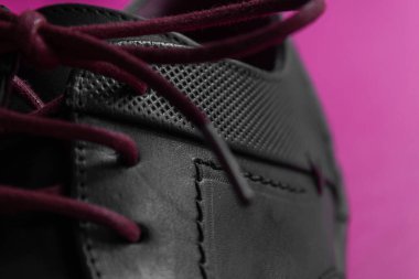 Pembe arka planı olan bir ayakkabının bağcıklarının ayrıntıları.