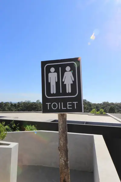 Toilettenschild mit Linsenschlag und blauem Himmel — Stockfoto