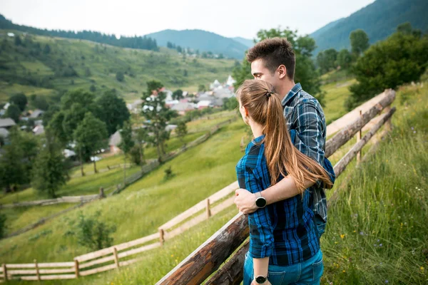 Chico y chica turistas relajarse y admirar hermosos paisajes de montaña —  Fotos de Stock
