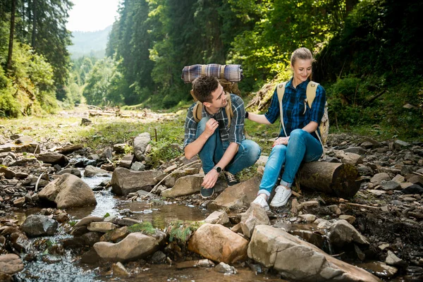 Fiú és lány szerelmesek turisták lazítson és csodálja meg a gyönyörű hegyi táj — Stock Fotó