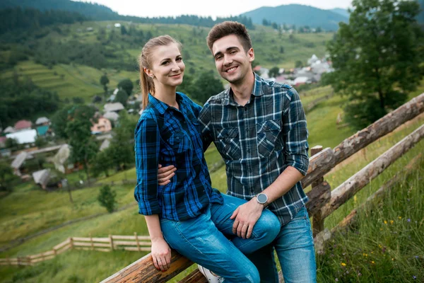 Guy and girl lovers tourists relax and admire beautiful mountain scenery — Stock Photo, Image