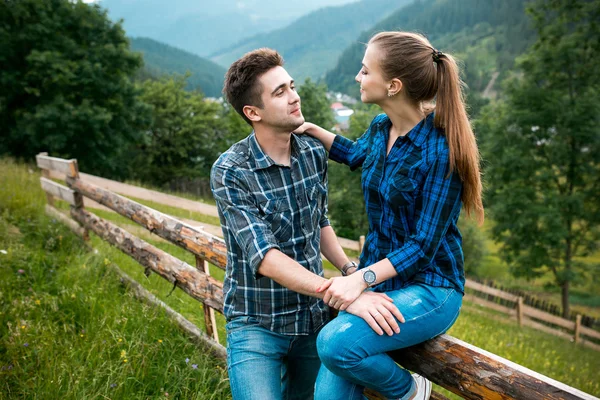 Guy and girl lovers tourists relax and admire beautiful mountain scenery — Stock Photo, Image