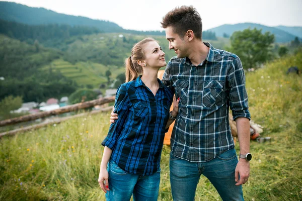 Guy and girl lovers tourists relax and admire beautiful mountain scenery — Stock Photo, Image