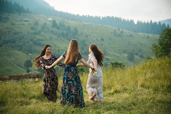 Girls girlfriend dresses rest on the nature in a beautiful mountain meadow Royalty Free Stock Photos