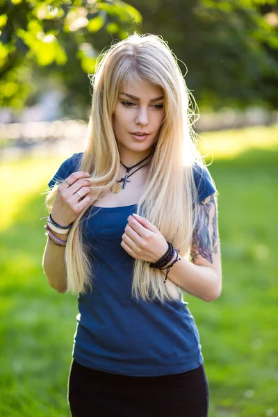 Портрет красивой молодой блондинки с длинными волосами и милой улыбкой на открытом воздухе — стоковое фото
