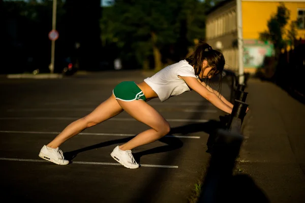 Krásná mladá brunetka dělá sport venku v létě — Stock fotografie