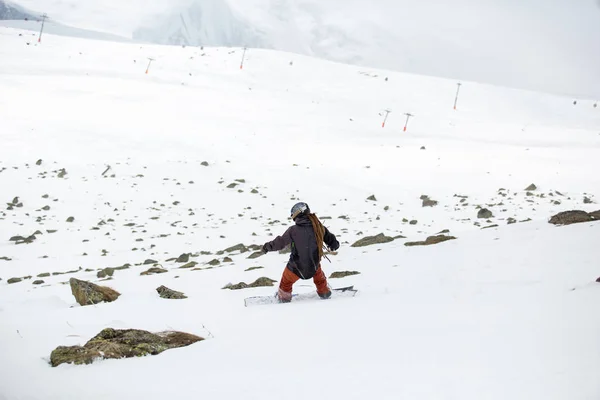 Snowboarder snowboard en nieve fresca en pista de esquí el soleado día de invierno en la estación de esquí de Georgia —  Fotos de Stock