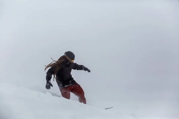 snowboarder snowboarding on fresh snow on ski slope on Sunny winter day in the ski resort in Georgia