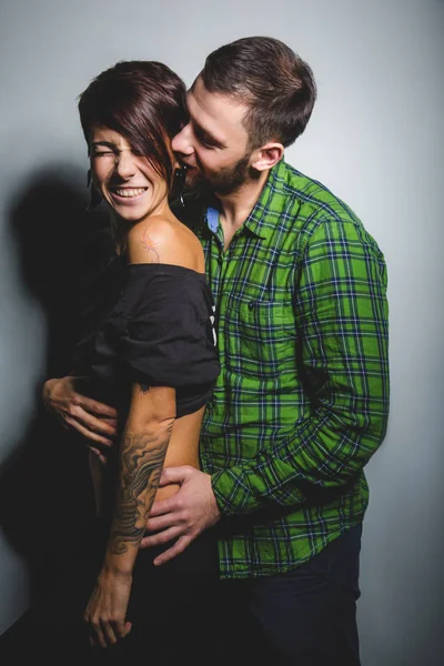 Hermosa pareja abrazándose y riendo en el fondo tein. El concepto de diversión, amor y felicidad —  Fotos de Stock
