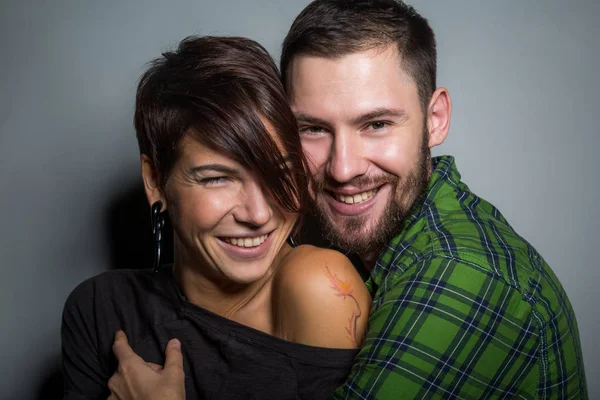 Belo casal abraçando e rindo no fundo do tein. O conceito de diversão, amor e felicidade — Fotografia de Stock