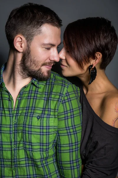 Belo casal abraçando e rindo no fundo do tein. O conceito de diversão, amor e felicidade — Fotografia de Stock