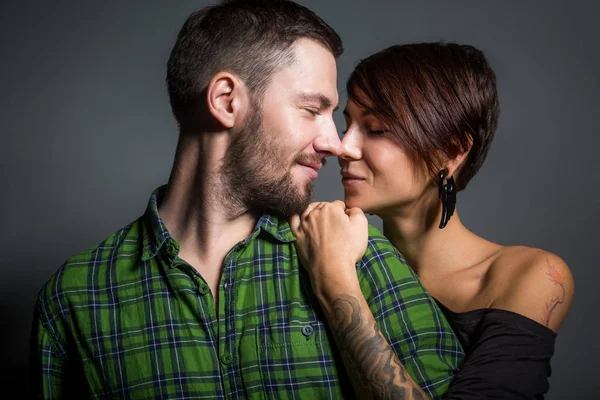 Belo casal abraçando e rindo no fundo do tein. O conceito de diversão, amor e felicidade — Fotografia de Stock