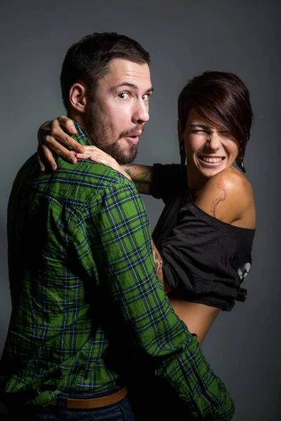 Beautiful couple hugging and laughing on the tein background. The concept of fun, love and happiness — Stock Photo, Image