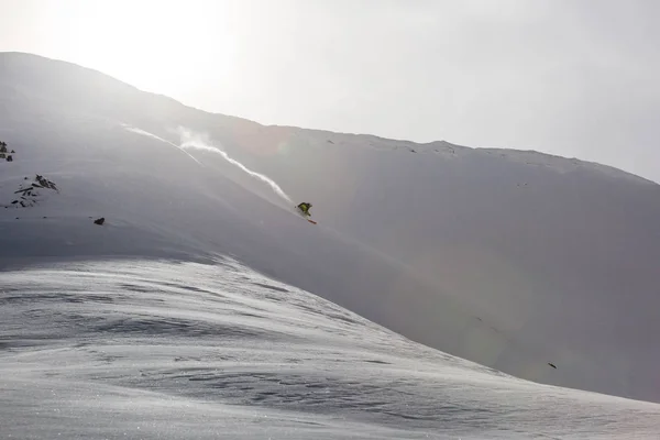 Αρσενικό snowboarder σνόουμπορντ στο φρέσκο χιόνι στην πίστα σκι, ηλιόλουστη χειμερινή ημέρα στο χιονοδρομικό κέντρο στη γεωργία — Φωτογραφία Αρχείου