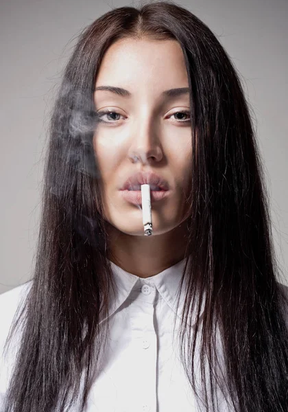 Young beautiful brunette girl with a cigarette in his mouth. The concept of bad habits — Stock Photo, Image