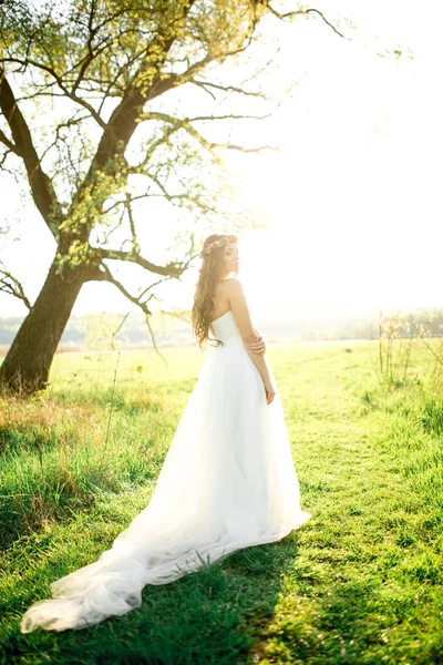 Красивая невеста в свадебном платье и с прекрасным настроением в природе — стоковое фото
