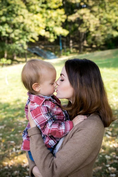 Beautiful Mother And Baby on nature. Beauty Mum and her Child playing in Park together. Outdoor Portrait of happy family. Joy. Mom and Baby