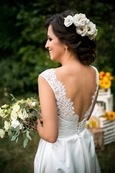 Retrato de noiva bonita em vestido de noiva com um belo buquê de flores — Fotografia de Stock