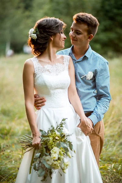 La novia y el novio abrazándose en la boda . — Foto de Stock