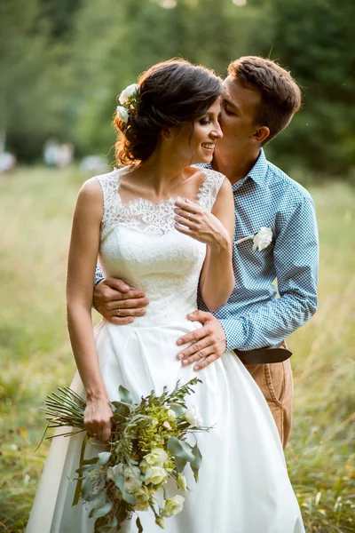 La novia y el novio abrazándose en la boda . — Foto de Stock