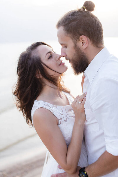 Beach honeymoon couple kissing and hugging on white sand beach