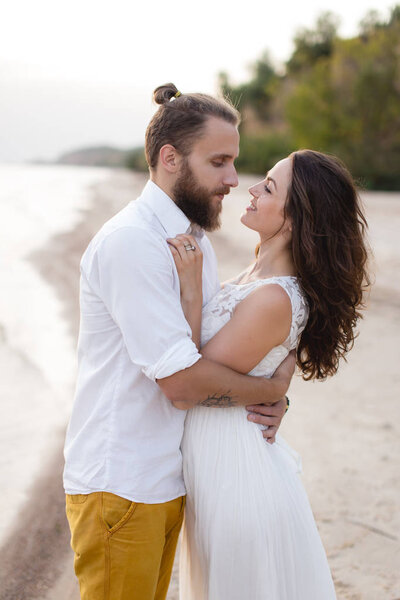 Beach honeymoon couple kissing and hugging on white sand beach