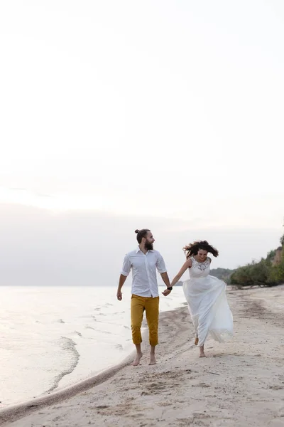Beach honeymoon couple kissing and hugging on white sand beach