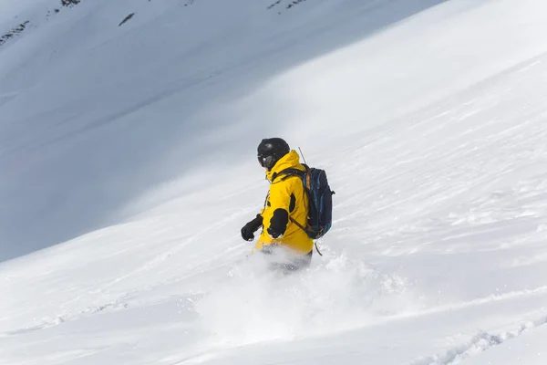 Αρσενικό snowboarder σνόουμπορντ στο φρέσκο χιόνι στην πίστα σκι, ηλιόλουστη χειμερινή ημέρα στο χιονοδρομικό κέντρο στη γεωργία — Φωτογραφία Αρχείου