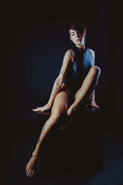 Donna bruna sexy in posa in lingerie elegante. Ragazza con corpo perfetto e tatuaggio — Foto Stock