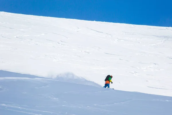 Snowboarder snowboard en nieve fresca en pista de esquí el soleado día de invierno en la estación de esquí de Georgia —  Fotos de Stock