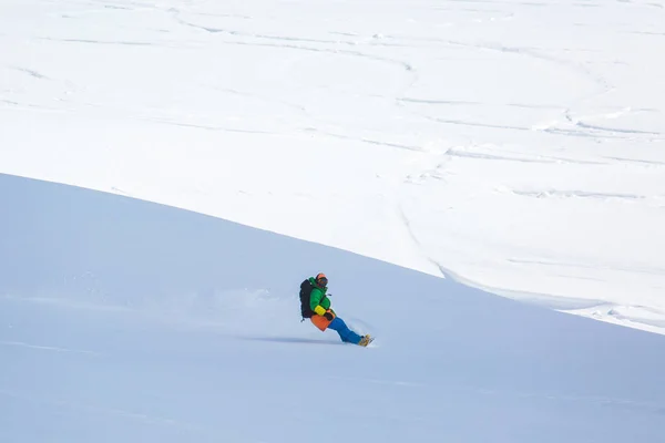 Snowboarder snowboarding on fresh snow on ski slope on Sunny winter day in the ski resort in Georgia — Stock Photo, Image