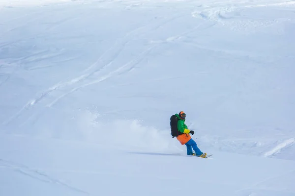 Snowboardzista, snowboard na świeżym śniegu na stoku narciarskiego na słoneczny zimowy dzień w ośrodku narciarskim w Gruzji — Zdjęcie stockowe