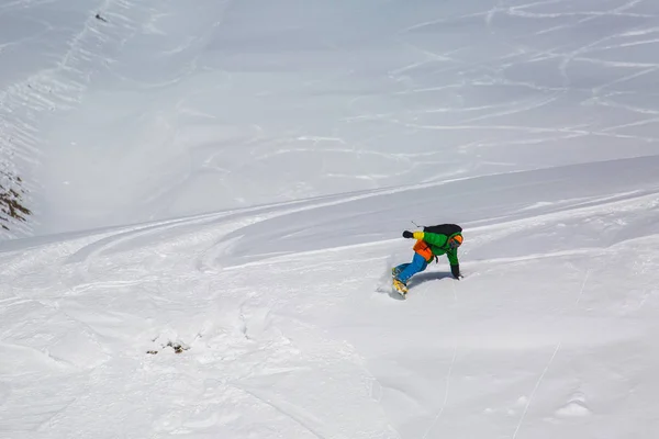 Snowboarder snowboarden op verse sneeuw op de skipiste op zonnige winterdag in het ski-oord in Georgië — Stockfoto
