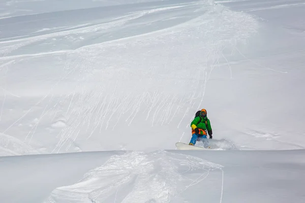 Snowboarder snowboard na neve fresca na pista de esqui no dia ensolarado de inverno na estância de esqui na Geórgia — Fotografia de Stock