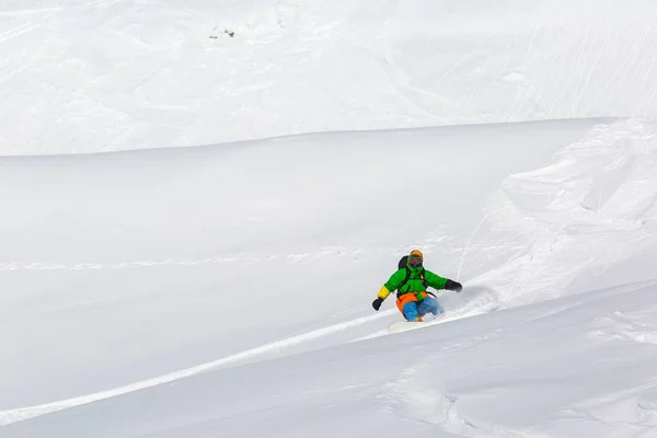 Snowboardzista, snowboard na świeżym śniegu na stoku narciarskiego na słoneczny zimowy dzień w ośrodku narciarskim w Gruzji — Zdjęcie stockowe