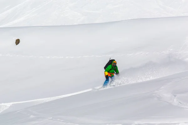 Snowboardzista, snowboard na świeżym śniegu na stoku narciarskiego na słoneczny zimowy dzień w ośrodku narciarskim w Gruzji — Zdjęcie stockowe