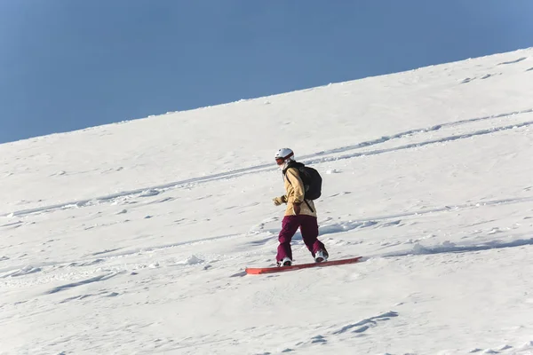 여자의 snowboarder 스키 슬로프와 맑은 겨울 날에 신선한 흰 눈에 스노우 보드 — 스톡 사진
