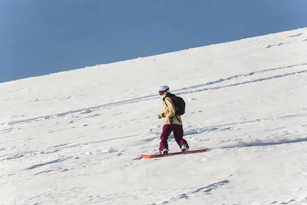 Női hódeszkás snowboardozás a friss fehér hó a sípálya a napsütéses téli nap — Stock Fotó