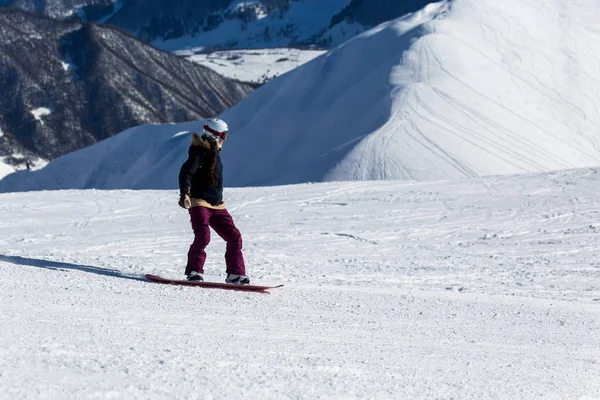 Női hódeszkás snowboardozás a friss fehér hó a sípálya a napsütéses téli nap — Stock Fotó