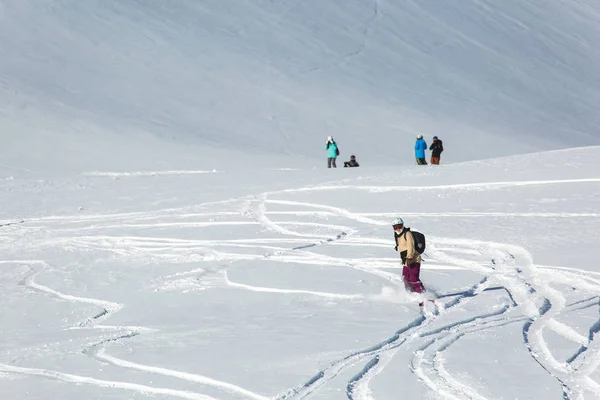 Vrouwen snowboarder snowboarden op verse witte sneeuw met skihelling op zonnige winterdag Stockafbeelding