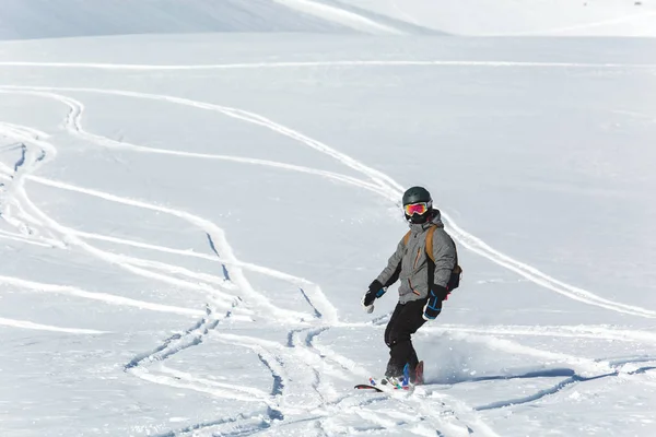 Snowboarder snowboard a friss hó, sípályák a napsütéses téli napon Grúziában síközpontban — Stock Fotó