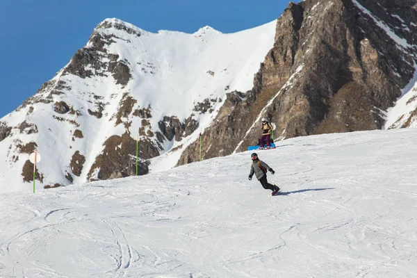 Snowboarder snowboard a friss hó, sípályák a napsütéses téli napon Grúziában síközpontban — Stock Fotó