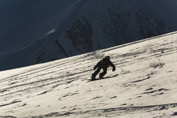 Snowboarder snowboard a friss hó, sípályák a napsütéses téli napon Grúziában síközpontban — Stock Fotó