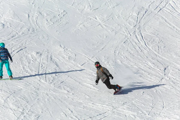 Snowboarder snowboard na neve fresca na pista de esqui no dia ensolarado de inverno na estância de esqui na Geórgia — Fotografia de Stock