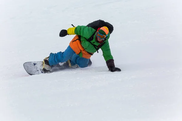 Snowboarder snowboarding on fresh snow on ski slope on Sunny winter day in the ski resort in Georgia — Stock Photo, Image