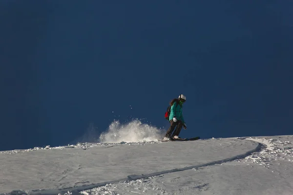Snowboarderin Snowboard auf Neuschnee mit Skipiste an sonnigem Wintertag — Stockfoto