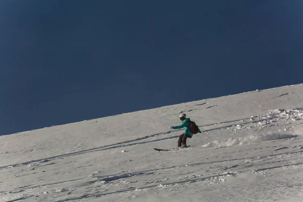 Snowboarder donna snowboard sulla neve fresca bianca con pista da sci nella giornata invernale soleggiata — Foto Stock