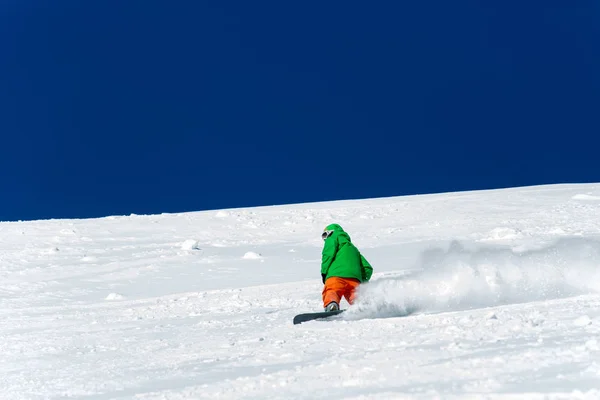 Snowboarder snowboard en nieve blanca fresca con pista de esquí en el soleado día de invierno — Foto de Stock