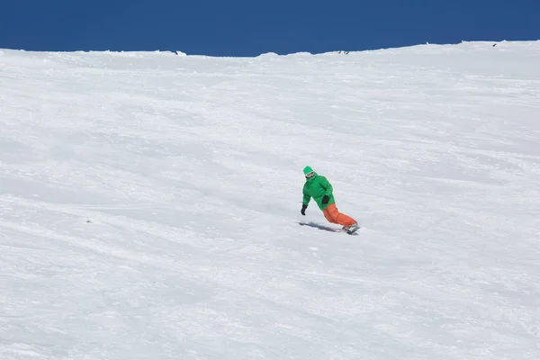 Snowboarder snowboard en nieve blanca fresca con pista de esquí en el soleado día de invierno —  Fotos de Stock