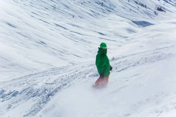 snowboarder snowboarding on fresh white snow with ski slope on Sunny winter day